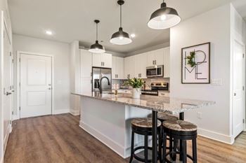 A kitchen with a bar stool and a counter.